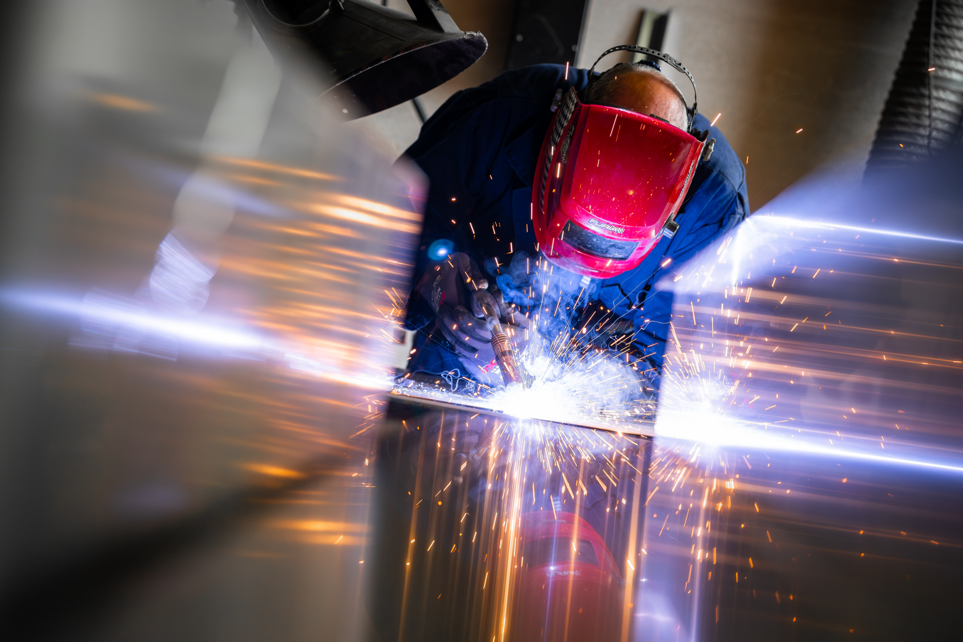 Persoon last met helm en vonken vliegen rond.