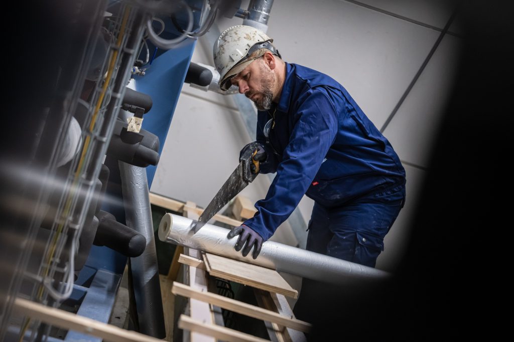 Man zaagt metaal in werkplaats