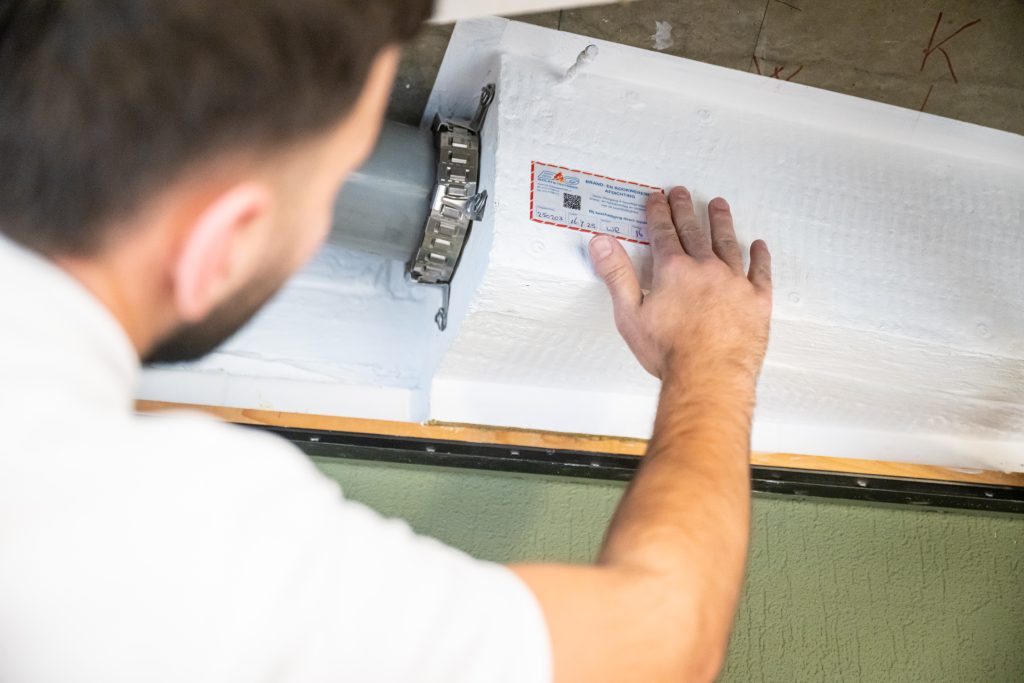 Man plaatst etiket op isolatiebuis