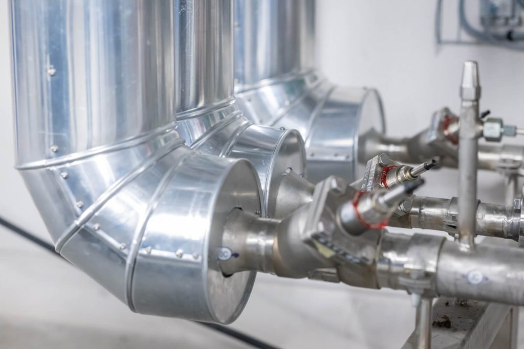 Zilveren industriële pijpleidingen en kleppen in fabriek