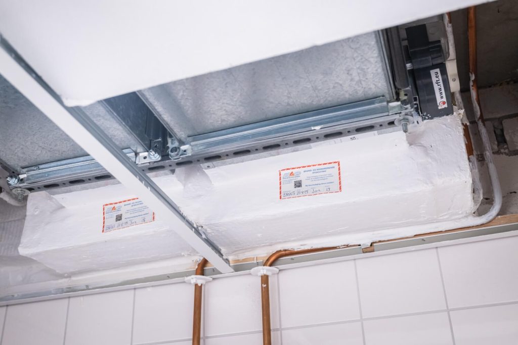 Brandwerende doorvoer in systeemplafond met labels.